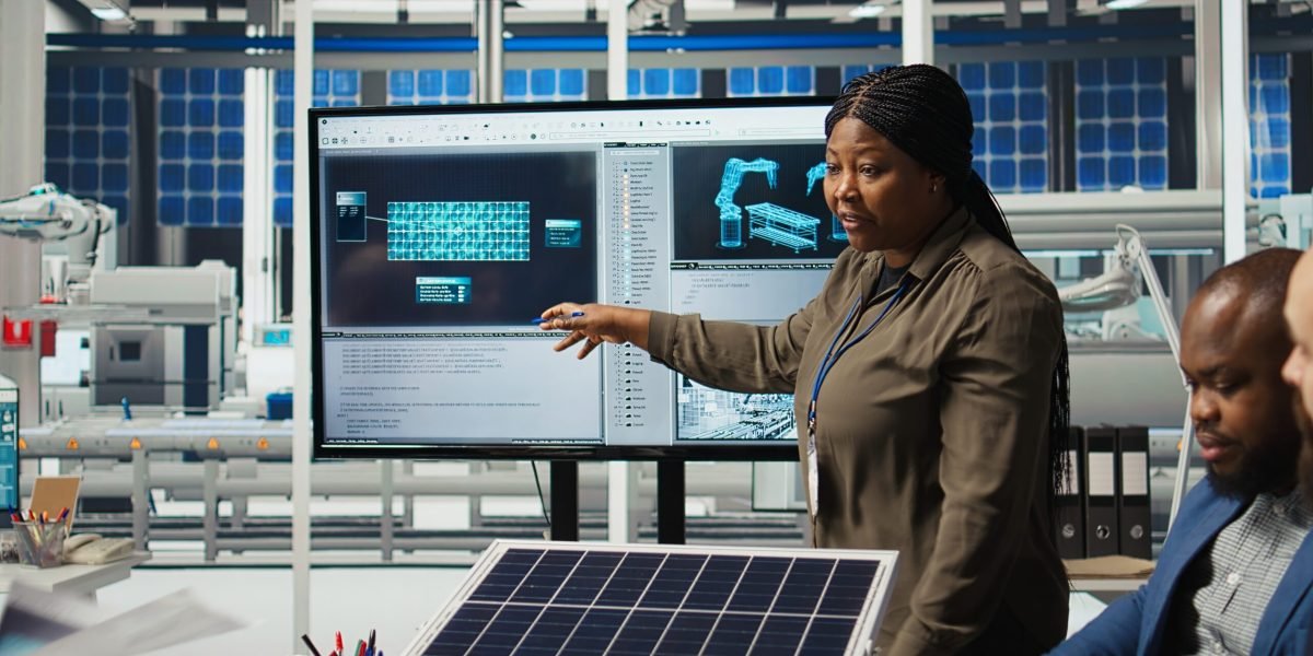 Shareholders discussing future investment opportunities in sustainable energy manufacturing. Management executives and investors in solar panels plant reviewing solar technology reports, camera A